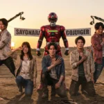 特撮番組『ゴジュウジャー』の最終回撮影現場。涙を流す5人のキャストと中央に立つ赤いメタルヒーロー、背景の「SAYONARA GOJUIGER」の横断幕と爆発シーンの舞台裏。